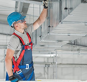 HVAC technician inspecting ductwork