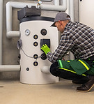 HVAC technician inspecting equipment, Herzing Heating.