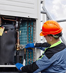 HVAC technician inspecting equipment for Herzing Heating.